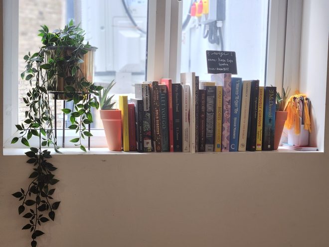 Window ledge styled with books, small plants and trailing ivy