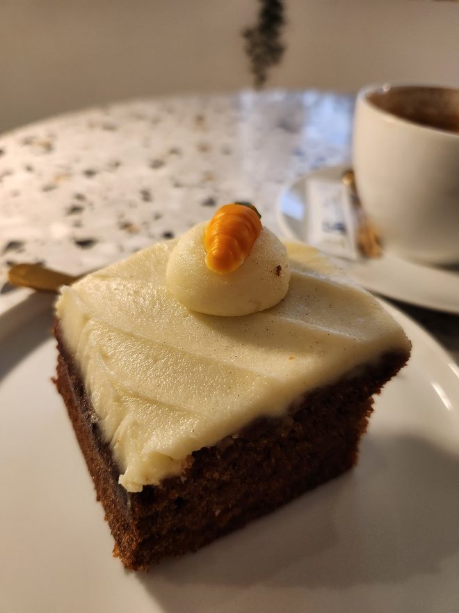 Carrot cake and a coffee on a terrazzo table