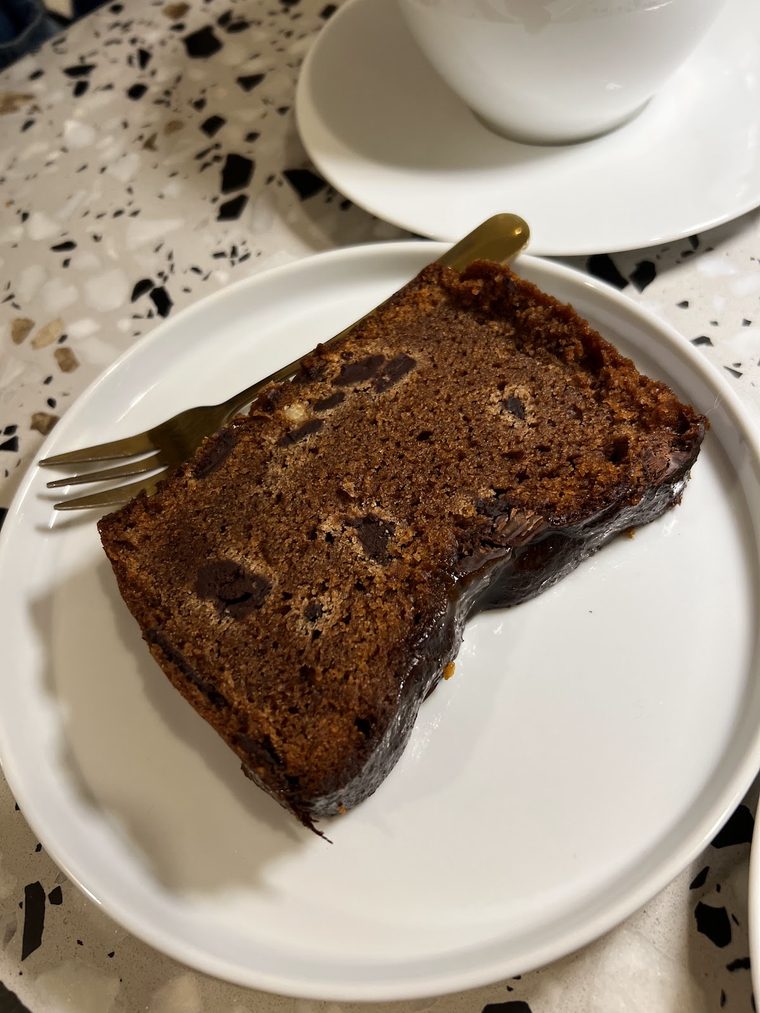Slice of dark loaf cake with a gold fork