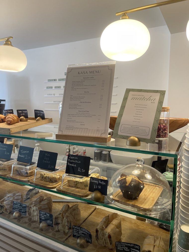 Counter pastry display case stocked with cakes and bakes, cropped to the glass case only